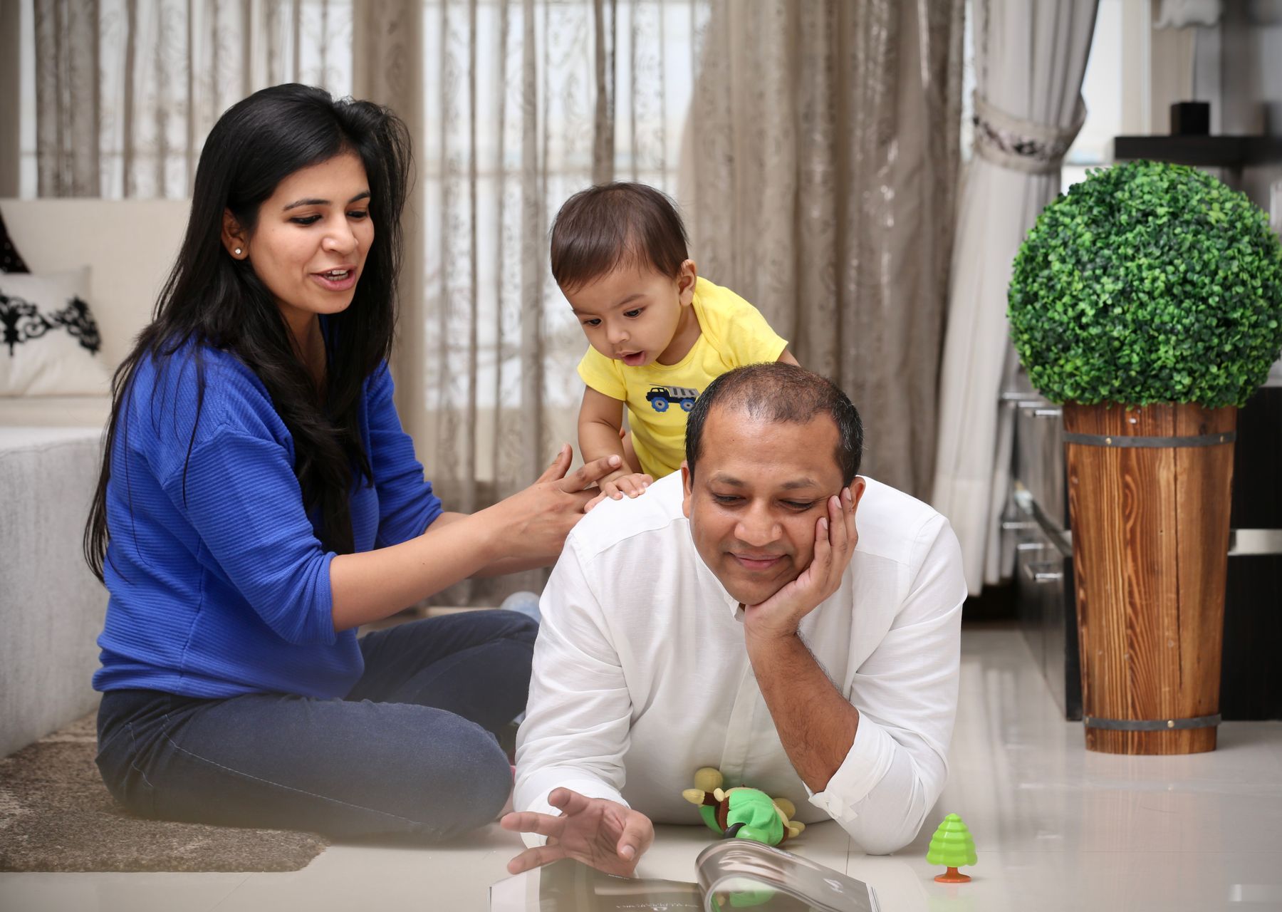 Illustrative photograph: A family sharing a playful moment in a bright, comfortably furnished living room.
